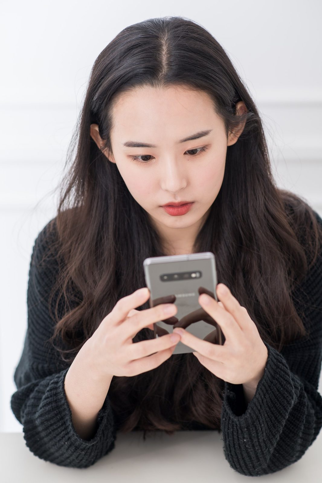 휴대폰을 보며 고개를 숙인 리얼 모델