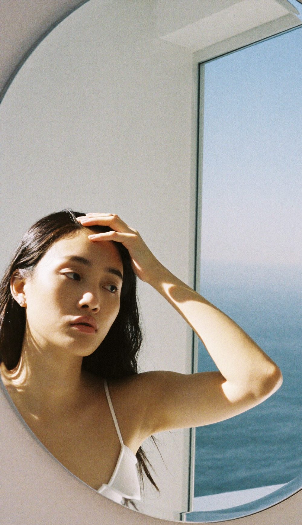 거울 앞에서 앞머리를 넘겨 보는 여성 — 긴 머리를 유지하는 비절개